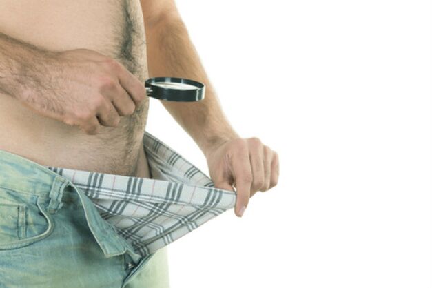 um homem olha para seu pênis e quer aumentá-lo